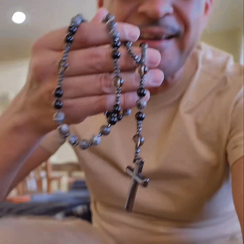 Rosary necklace shown by hand